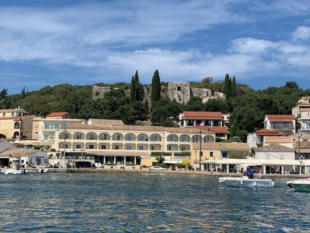 A castle structure is viewed from a boat in Corfu.