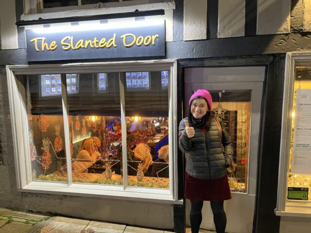 Woman standing at the door of a Restaurant on a quick jaunt to Stamford trip.