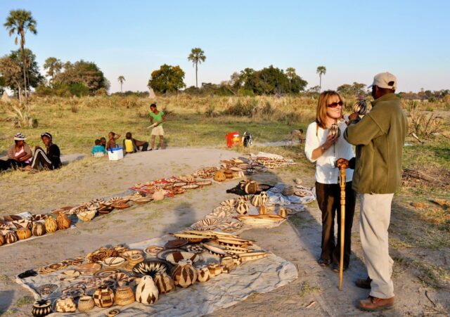 A tourist is having a conversation with a village market vendor in Botswana.