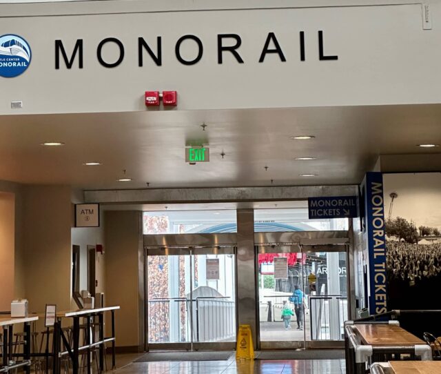 A monorail station in Seattle with entrance and exit signs for passengers.