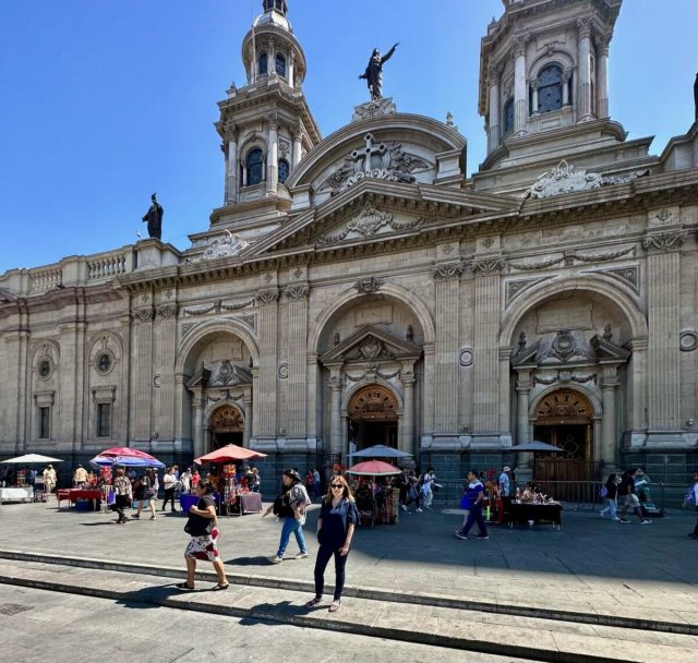 Travel blogger Jude in front of Cathedral Santiago Chile. Market stalls sell to visitors around the buildings main entrances.