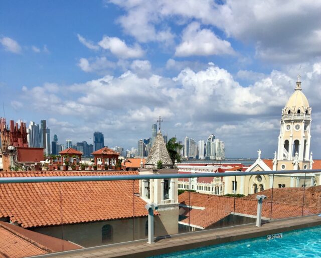 Clay tile rooftops of Old Panama City and behind them skyscrapers of modern Panama City.
