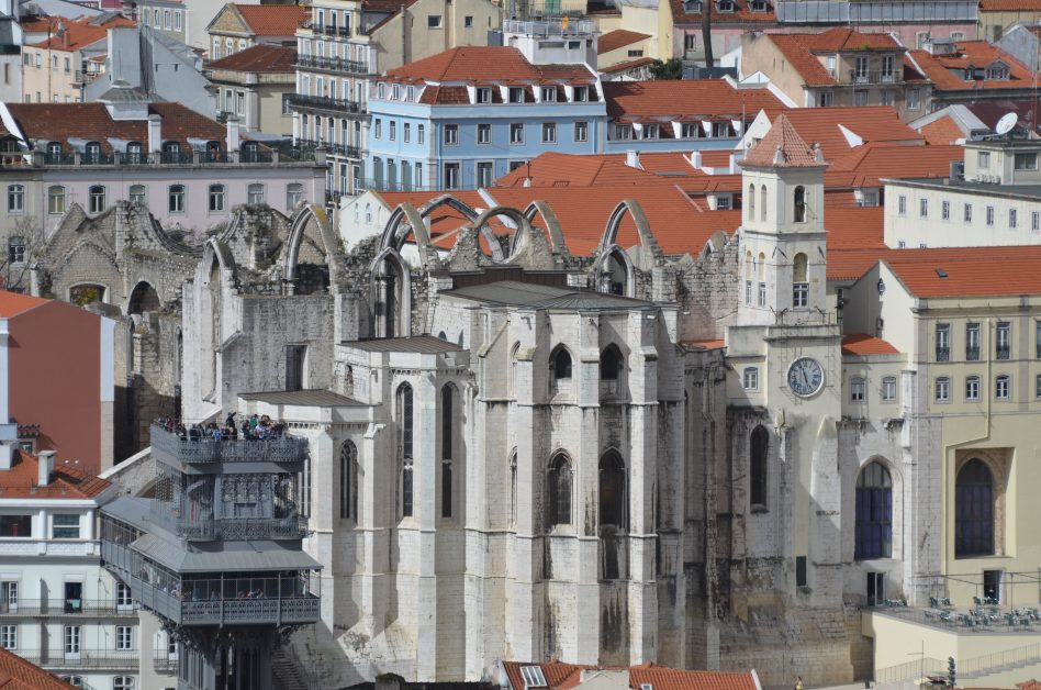 central Lisbon with a dense set of buildings, churches and lots of red tile roofs.