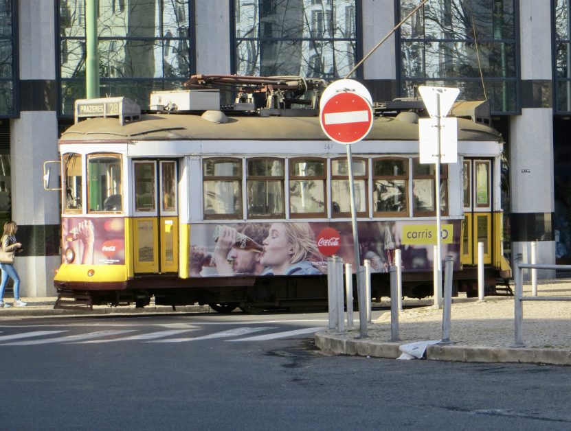 A street tram with cables connecting the carriage to its power source.