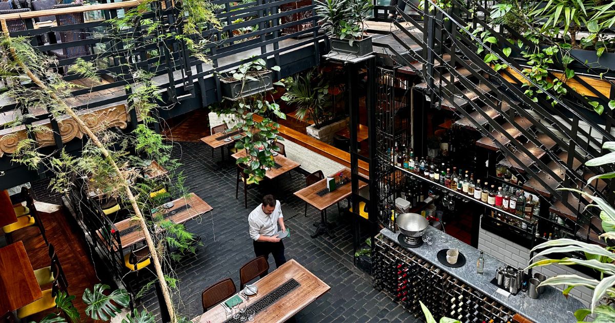 View of a restaurant in Glasgow with greenery and tables set for lunch.